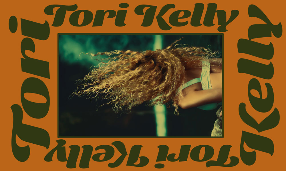Green text reading Tori Kelly on an orange background surrounding the photo of a woman with curly hair with her face obscured.
